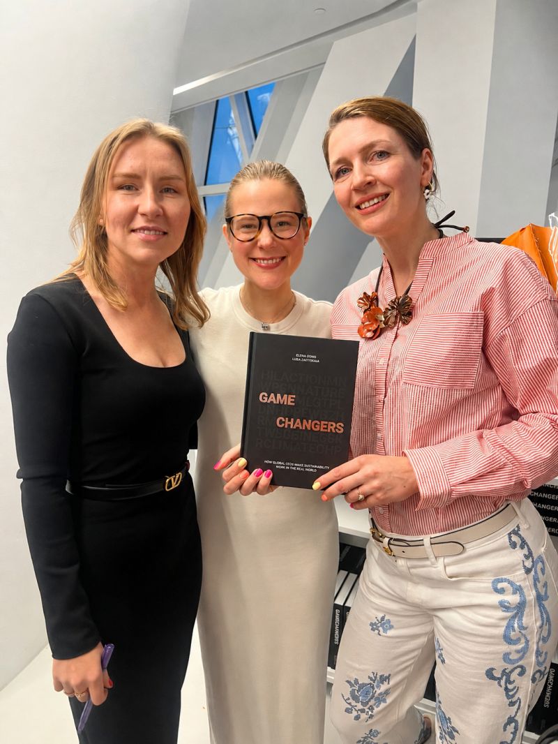 Luba Karpova with two colleagues holding a copy of the book Game Changers.